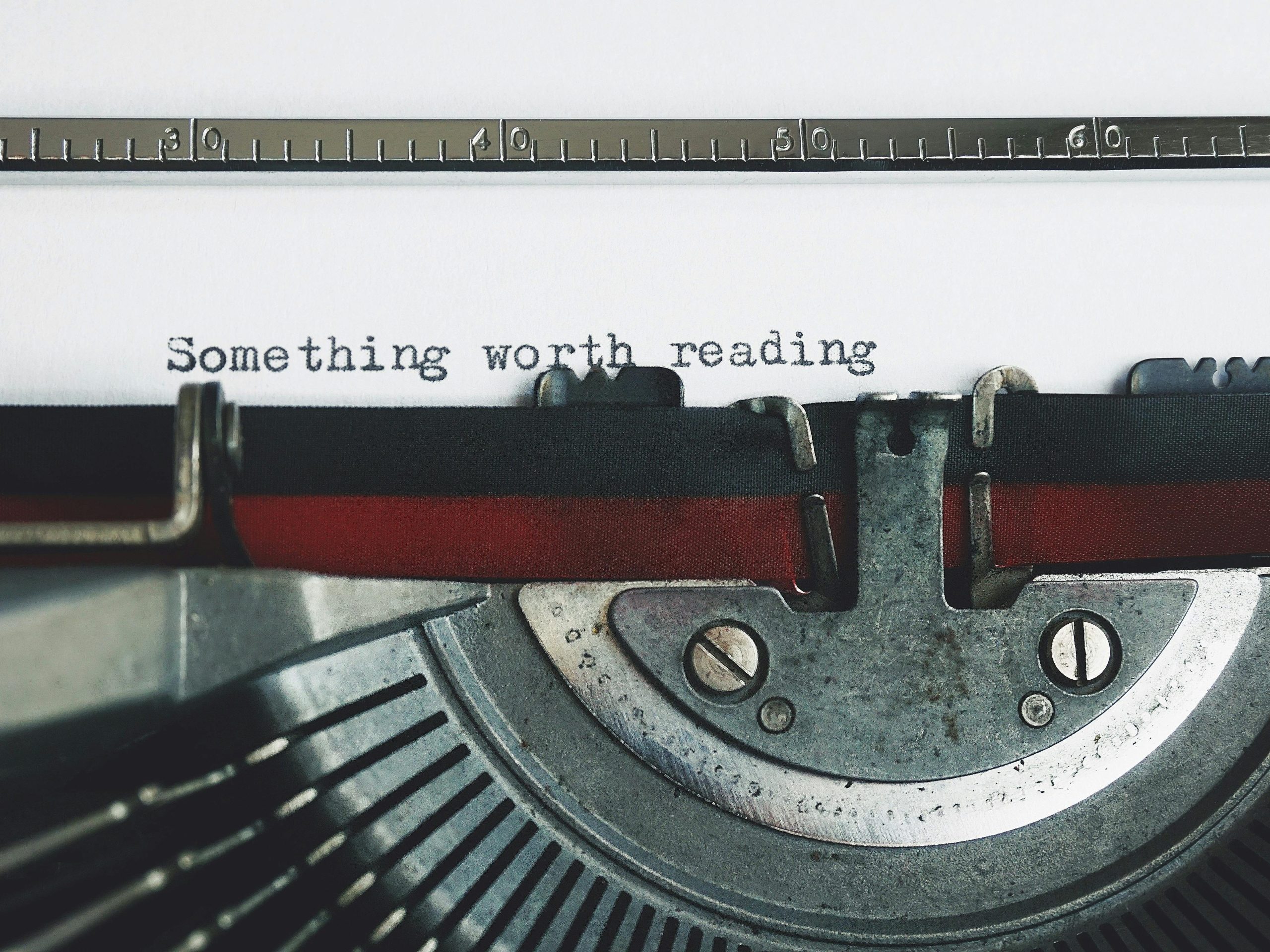 Close-up of a vintage typewriter with the phrase 'Something worth reading'.